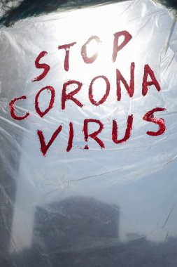 Pencereye asılmış politen yüzey üzerindeki Corona Virüsü yazısını durdur. Coronavirus (Covid-19) salgını.