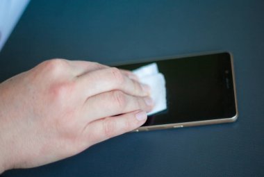 Islak antibakteriyel mendille akıllı telefonu temizlemek. Farklı virüs ve bakterilerin yayılmasını önlemek için telefonu sterilize ediyorum. Coronavirus (Covid-19) salgını. 