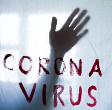 Beyaz bir kağıda Corona Virüsü yazılıydı. Çarşafın arkasındaki elin silueti. Coronavirus (Covid-19) salgını. Karantina. 