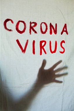 Beyaz bir kağıda Corona Virüsü yazılıydı. Çarşafın arkasındaki elin silueti. Coronavirus (Covid-19) salgını. Karantina. 