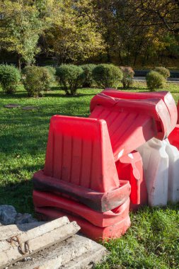 Çimlerin üzerinde beyaz ve kırmızı güvenlik bariyerleri.