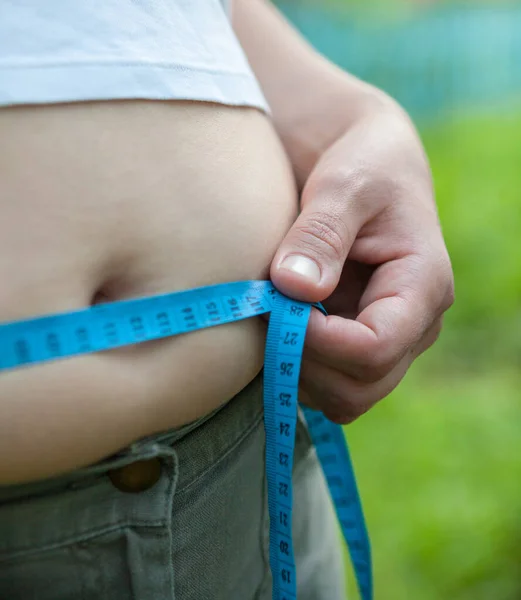 大肚子的女人用带子测量腰围 — 图库照片