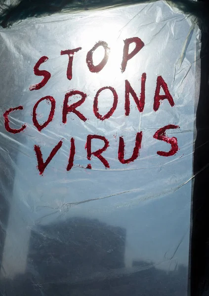 Stop Corona Virus inscription on a polythene surface hanging on a window. Coronavirus (Covid-19) disease outbreak.