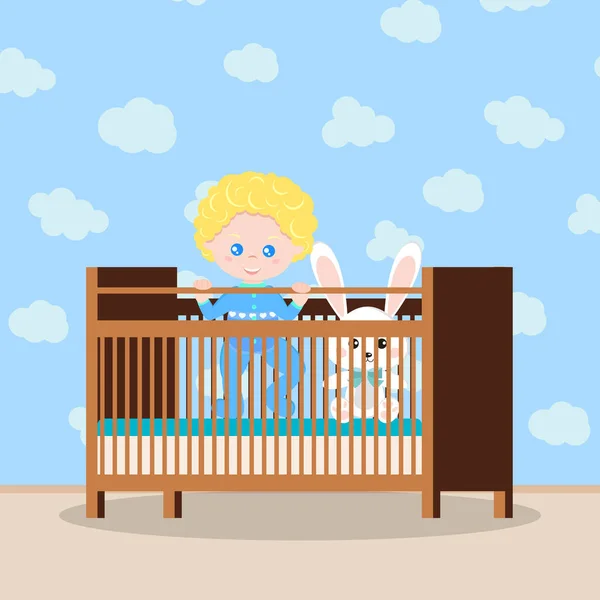 Bébé garçon heureux en vêtements de nuit bleus debout dans la crèche en bois avec jouet doux . — Image vectorielle