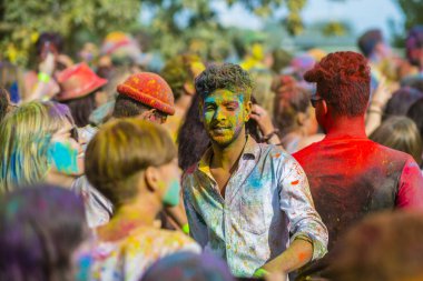 Montreal, Canada - August 10, 2019: People celebrate HOLI Festival throwing color powders in Horloge Park in Montreal