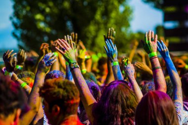 Montreal, Canada - August 10, 2019: People celebrate HOLI Festival throwing color powders in Horloge Park in Montreal