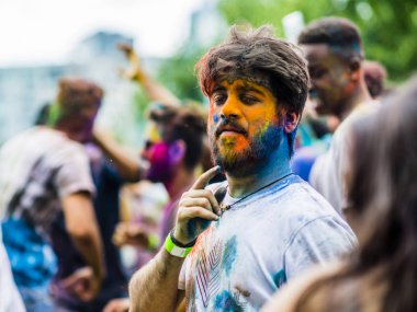 Montreal, Canada - August 10, 2019: People celebrate HOLI Festival throwing color powders in Horloge Park in Montreal