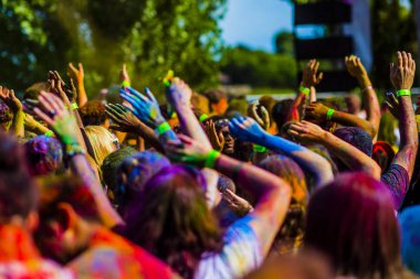 Montreal, Canada - August 10, 2019: People celebrate HOLI Festival throwing color powders in Horloge Park in Montreal