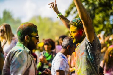 Montreal, Canada - August 10, 2019: People celebrate HOLI Festival throwing color powders in Horloge Park in Montreal