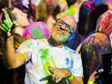 Montreal, Canada - August 10, 2019: People celebrate HOLI Festival throwing color powders in Horloge Park in Montreal