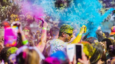 Montreal, Canada - August 10, 2019: People celebrate HOLI Festival throwing color powders in Horloge Park in Montreal