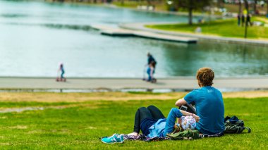 Montreal, Canada - May 12, 2019: Young couple enjoying the afternoon by the lake of castor in Mont-Royal of Montreal