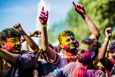 Montreal, Canada - August 10, 2019: People celebrate HOLI Festival throwing color powders in Horloge Park in Montreal