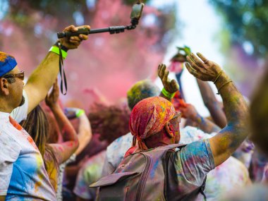 Montreal, Canada - August 10, 2019: People celebrate HOLI Festival throwing color powders in Horloge Park in Montreal