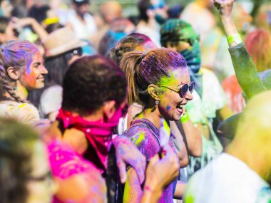 Montreal, Canada - August 10, 2019: People celebrate HOLI Festival throwing color powders in Horloge Park in Montreal