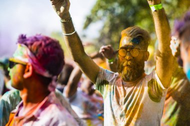 Montreal, Canada - August 10, 2019: People celebrate HOLI Festival throwing color powders in Horloge Park in Montreal