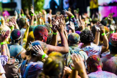 Montreal, Canada - August 10, 2019: People celebrate HOLI Festival throwing color powders in Horloge Park in Montreal