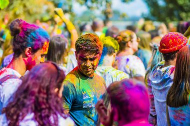 Montreal, Canada - August 10, 2019: People celebrate HOLI Festival throwing color powders in Horloge Park in Montreal