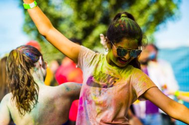 Montreal, Canada - August 10, 2019: People celebrate HOLI Festival throwing color powders in Horloge Park in Montreal