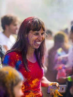 Montreal, Canada - August 10, 2019: People celebrate HOLI Festival throwing color powders in Horloge Park in Montreal