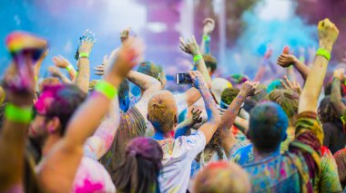 Montreal, Canada - August 10, 2019: People celebrate HOLI Festival throwing color powders in Horloge Park in Montreal