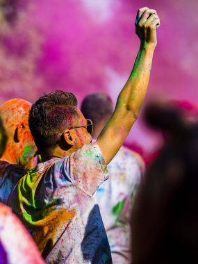 Montreal, Canada - August 10, 2019: People celebrate HOLI Festival throwing color powders in Horloge Park in Montreal