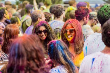 Montreal, Canada - August 10, 2019: People celebrate HOLI Festival throwing color powders in Horloge Park in Montreal