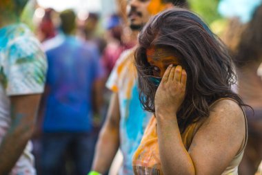Montreal, Canada - August 10, 2019: People celebrate HOLI Festival throwing color powders in Horloge Park in Montreal