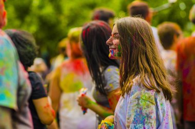 Montreal, Canada - August 10, 2019: People celebrate HOLI Festival throwing color powders in Horloge Park in Montreal