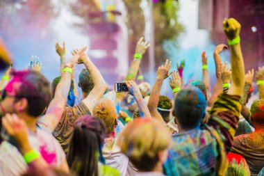 Montreal, Canada - August 10, 2019: People celebrate HOLI Festival throwing color powders in Horloge Park in Montreal