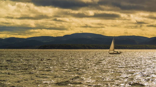 Saguenay River, Canada - August 18, 2019: Sailing boat on Saguenay River Valley during sunset