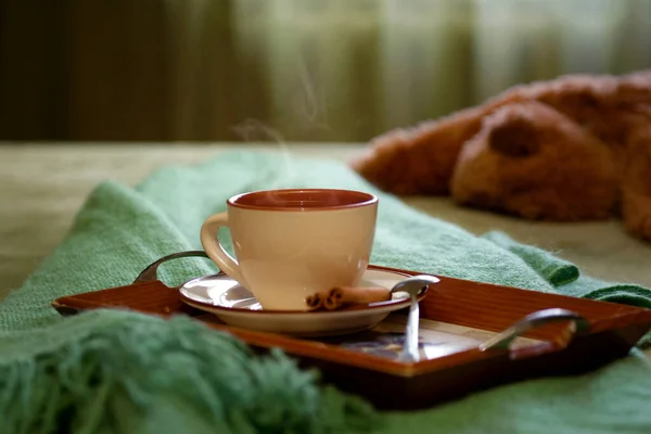 Cup of tea on a tray on the bed