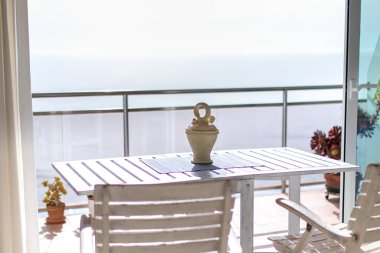 Deniz kenarındaki sandalyeli balkon.