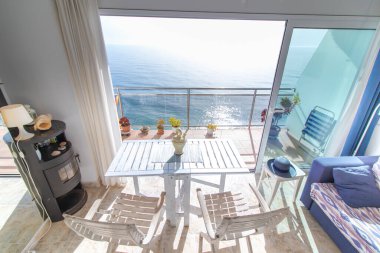 Deniz kenarındaki sandalyeli balkon.