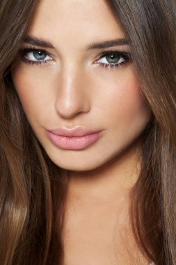 Heterokromi ve uzun sarı saçlı, gri stüdyo arka planında beyaz bir kadın..