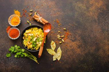 Biryani pirinç, geleneksel Hint yemeği. Baharatlı biryani pirinç, tavuk, fındık. Hint Pilav kasesi, baharatlar, bitkiler, rustik taş arka plan. Üstten görünüm. Metin için yer. Asya tarzı biryani pirinç. Hint yemeği