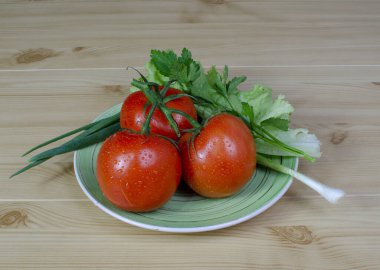 Bahçeden yeşil yapraklı domatesler ahşap bir masa arkasında kompozisyonda marul.
