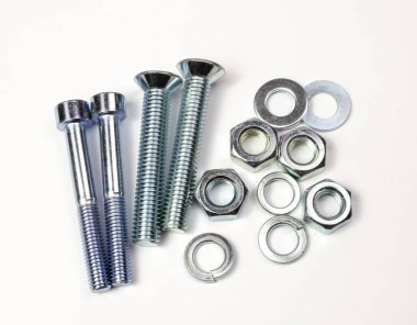 Bir grup büyük metal ürünü, cıvatalar, fındıklar, çamaşır makineleri yakından çekiliyor. Parlak krom parçalar