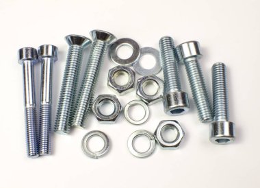 Bir grup büyük metal ürünü, cıvatalar, fındıklar, çamaşır makineleri yakından çekiliyor. Parlak krom parçalar