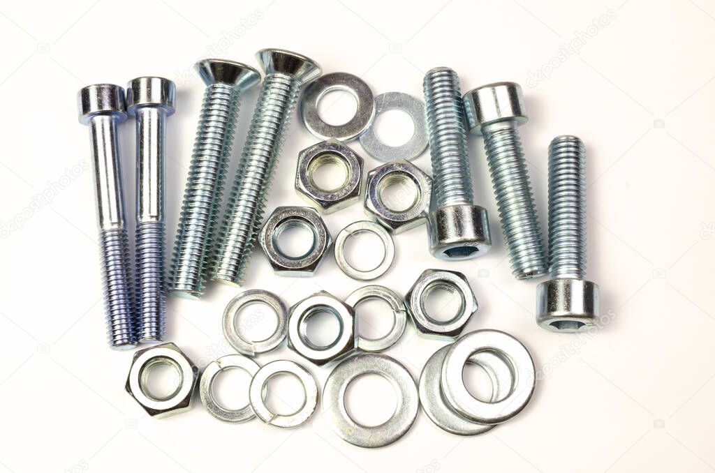 A group of large metal products, bolts, nuts, washers is shot close-up. shiny chrome parts