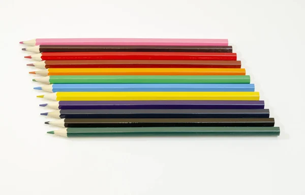 不同颜色的铅笔排列在白色表面上 — 图库照片