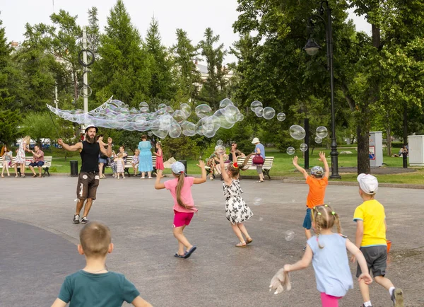 Merkez meydanda, Omsk 07 / 21 / 2019 'da bir grup çocuğun katıldığı bir sabun balonu gösterisi var.