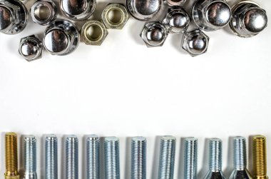 Beyaz arka planda yeni parlak fındıklar ve yazıtlar için yeri olan araba tekerlekleri için cıvatalar.