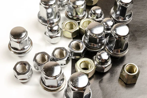 Masadaki beyaz arka planı olan bir araba için fındık ve cıvatalar.