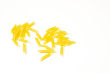 Beyaz arka planda bir sürü sarı makarna yığını var.