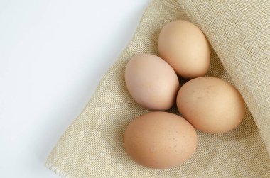 Koyu arkaplanda dört kahverengi tavuk yumurtası.