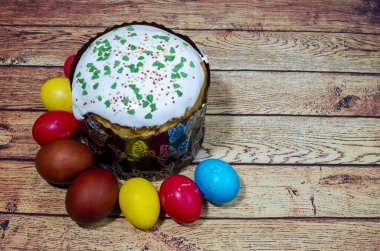 Paskalya bayramı için boyanmış yumurta ve pasta Tahta bir masanın üzerinde uzanır