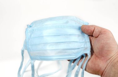 Adamın elinde koruyucu bir maske var. Koronovirüs için endişeleniyor.