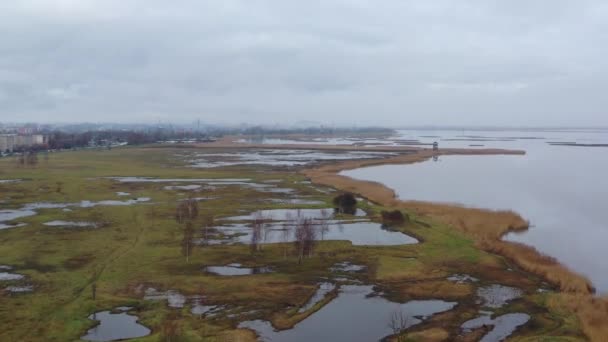 Ascensão subindo acima da costa molhada do Lago Liepaja com a cidade em segundo plano drone imagens aéreas — Vídeo de Stock