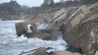 Büyük deniz dalgaları eski harabe savaş tahkimatlarına çarpıyor. Karosta, Liepaja, Letonya